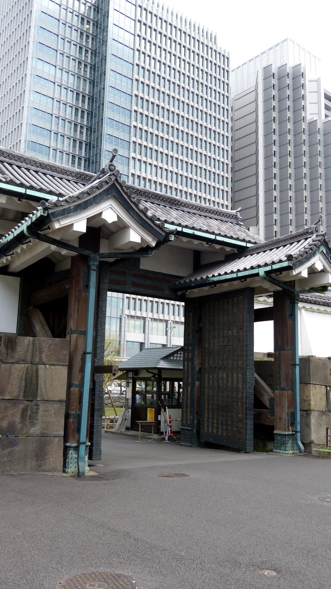 exterior of the entrance with traditional tiled roofing and stonework with modern skyscrapers in the background